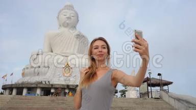 慢动作模特年轻女士在<strong>泰国佛像</strong>附近的智能手机上自拍。